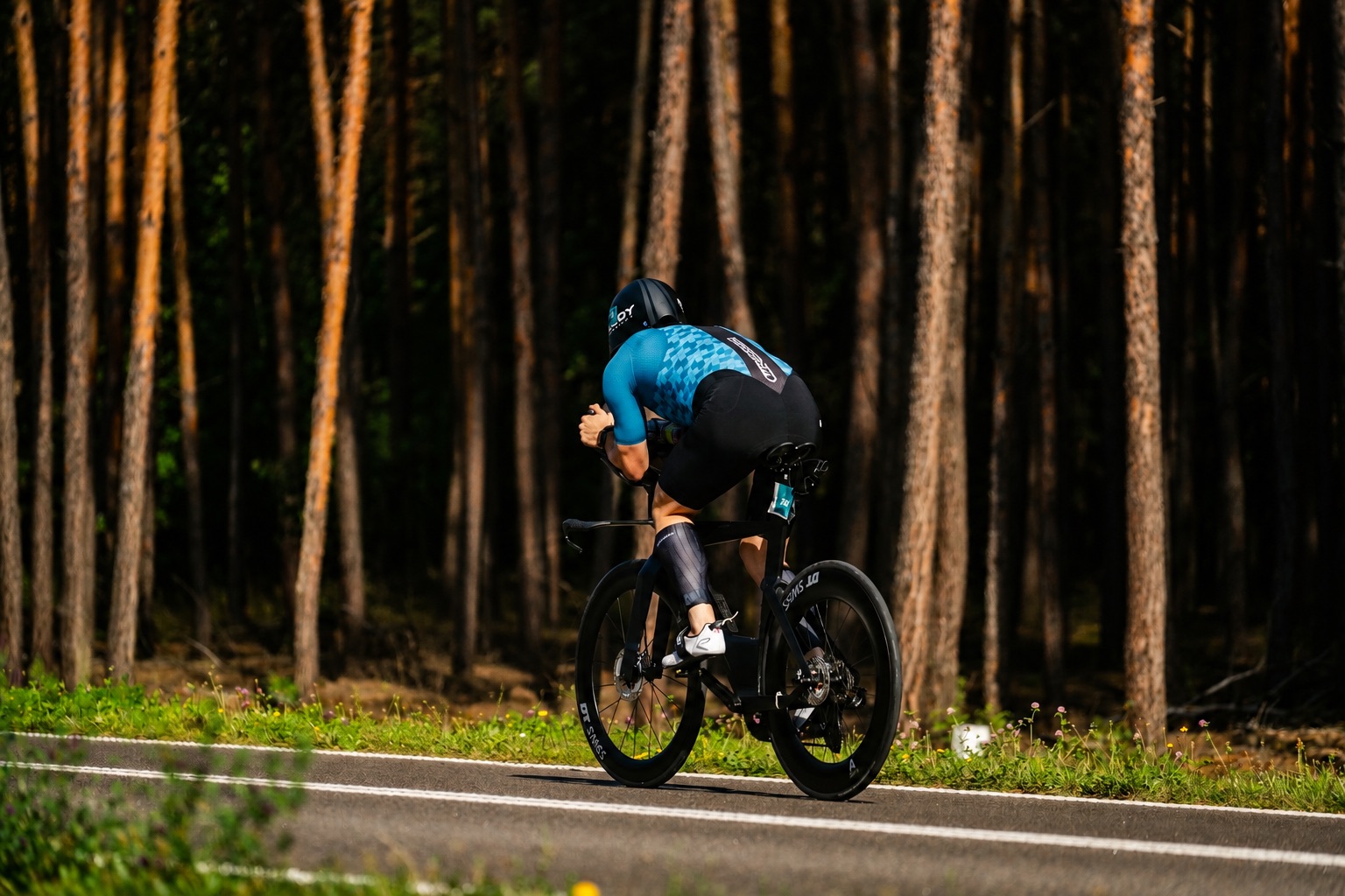 Triathlonista na rowerze czasowym na leśnej drodze